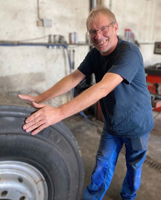 Mechaniker mit LKW-Reifen